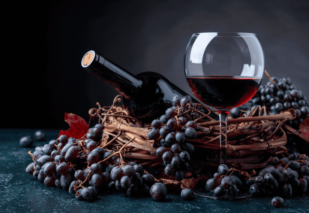 bouteille de vin rouge avec verre de vin et grappe de raisin