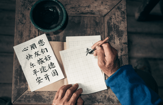 homme écrivant le chinois sur un papier