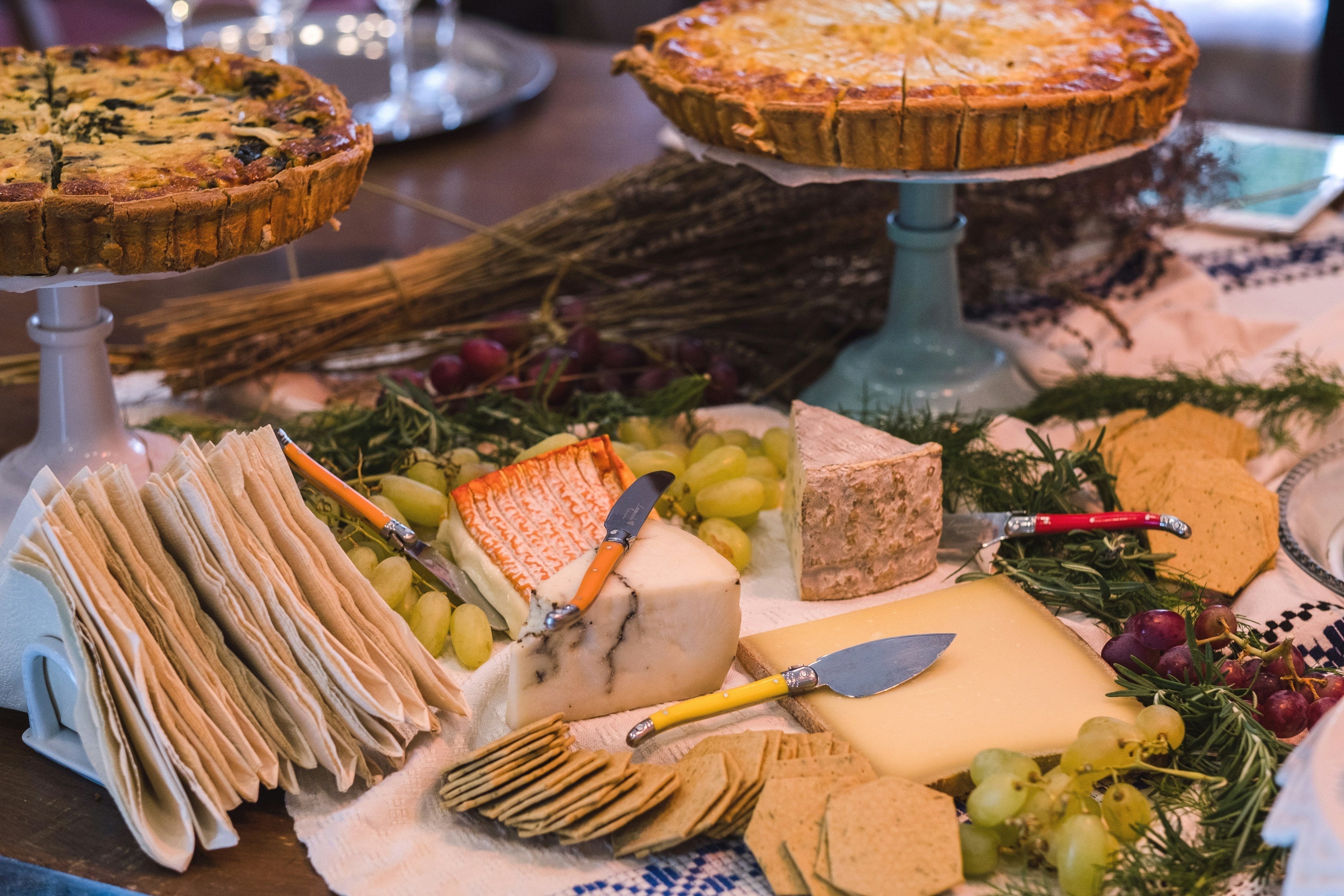 tableau avec plateau de fromages, tartes, pains, quiches, raisons