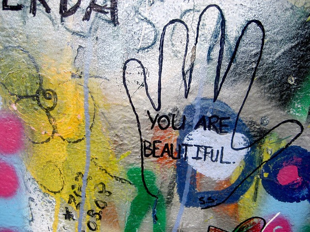 graffiti coloré avec une main et un compliment "you are beautiful"