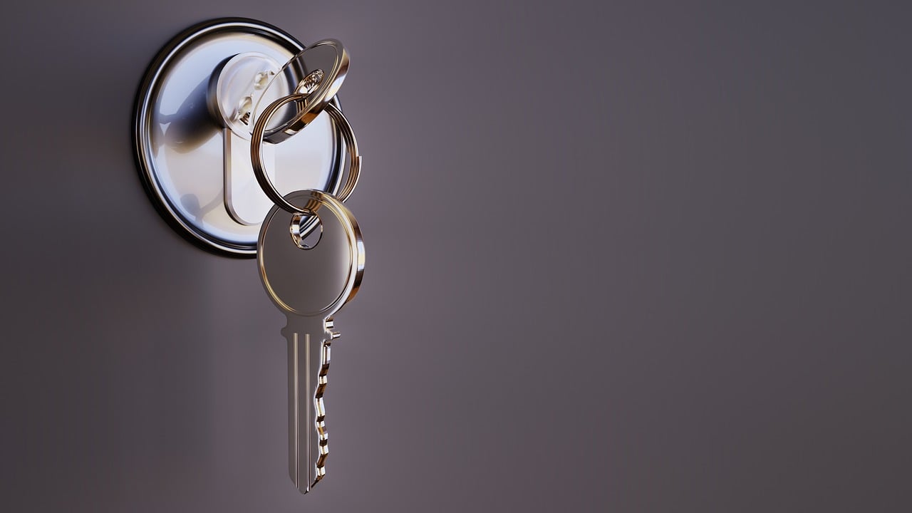 Clé sur porte sur un porte clé fond gris