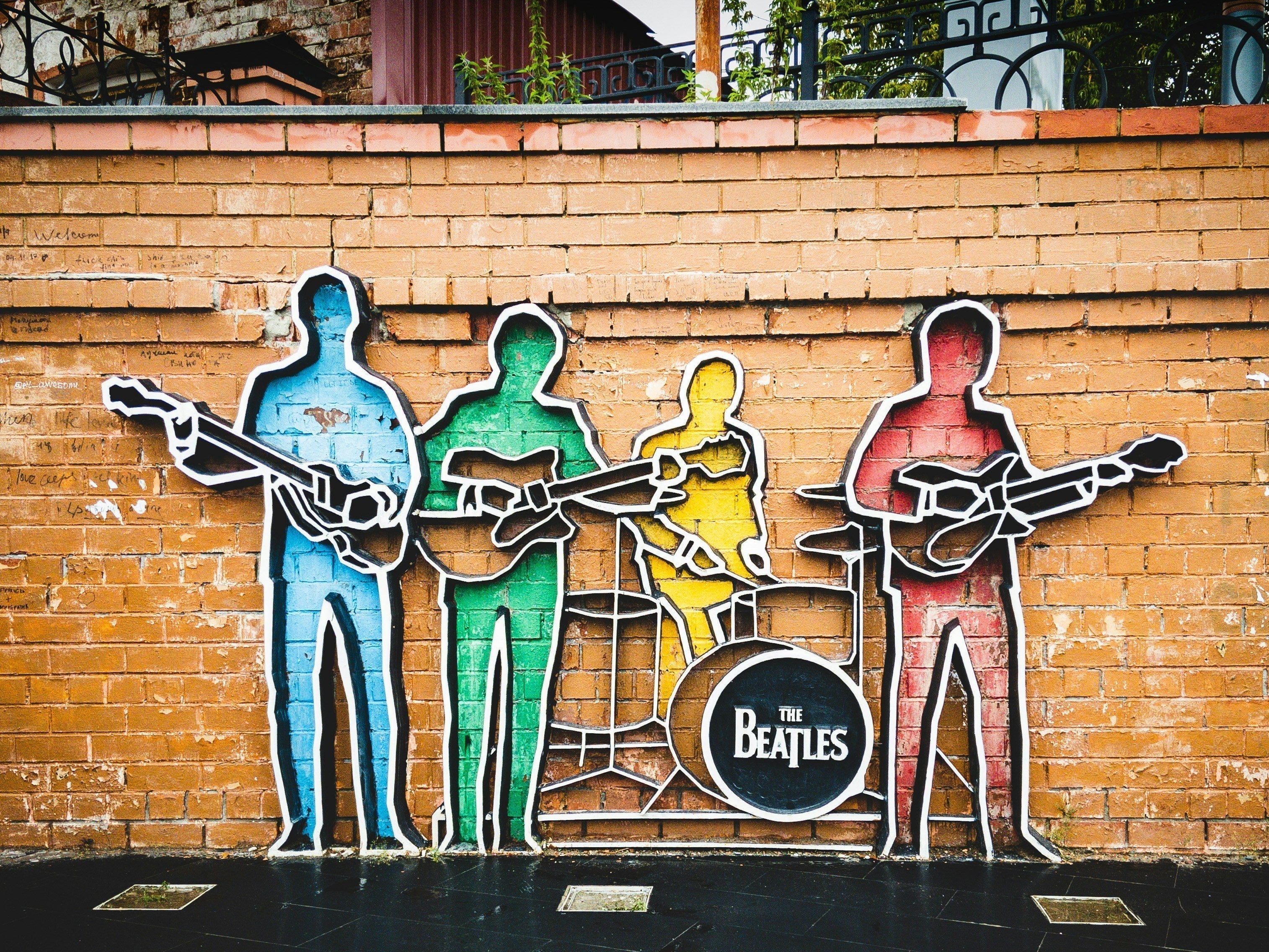 effet sculptures sur le mur représentant le groupe avec des couleurs et des instruments 