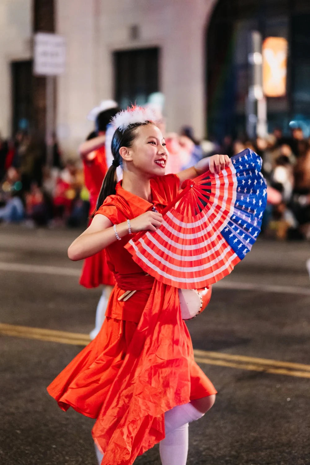 femme asiatique vêtue d'une robe rouge avec un éventail drapeau américain