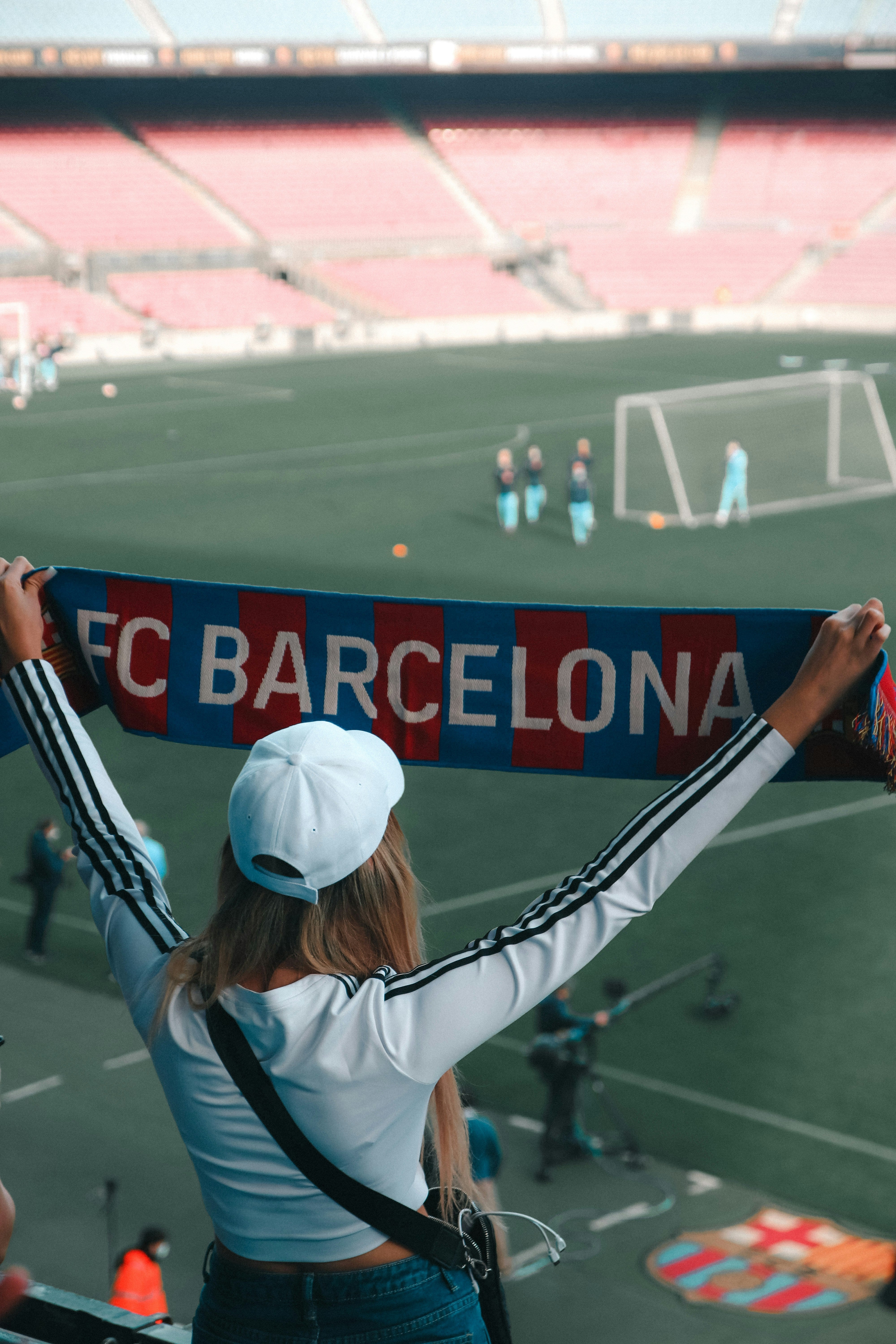 supportrice de dos qui tend une écharpe aux couleurs de l'équipe du FC Barcelone