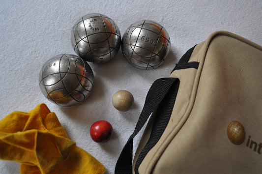 Jeux de boules avec deux cochonnets et un sac beige