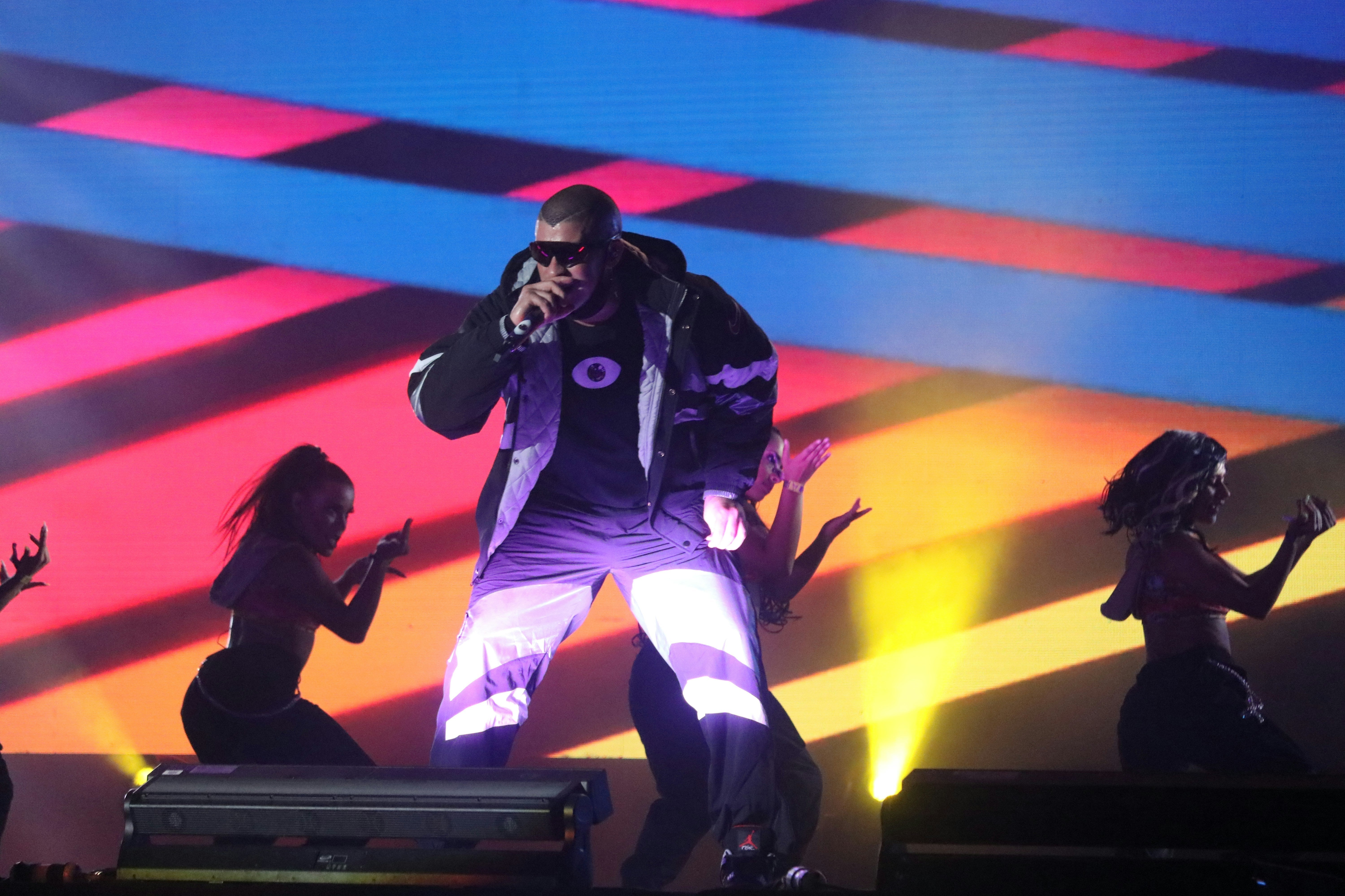 bad bunny sur scène décor en neon avec des danseuses 