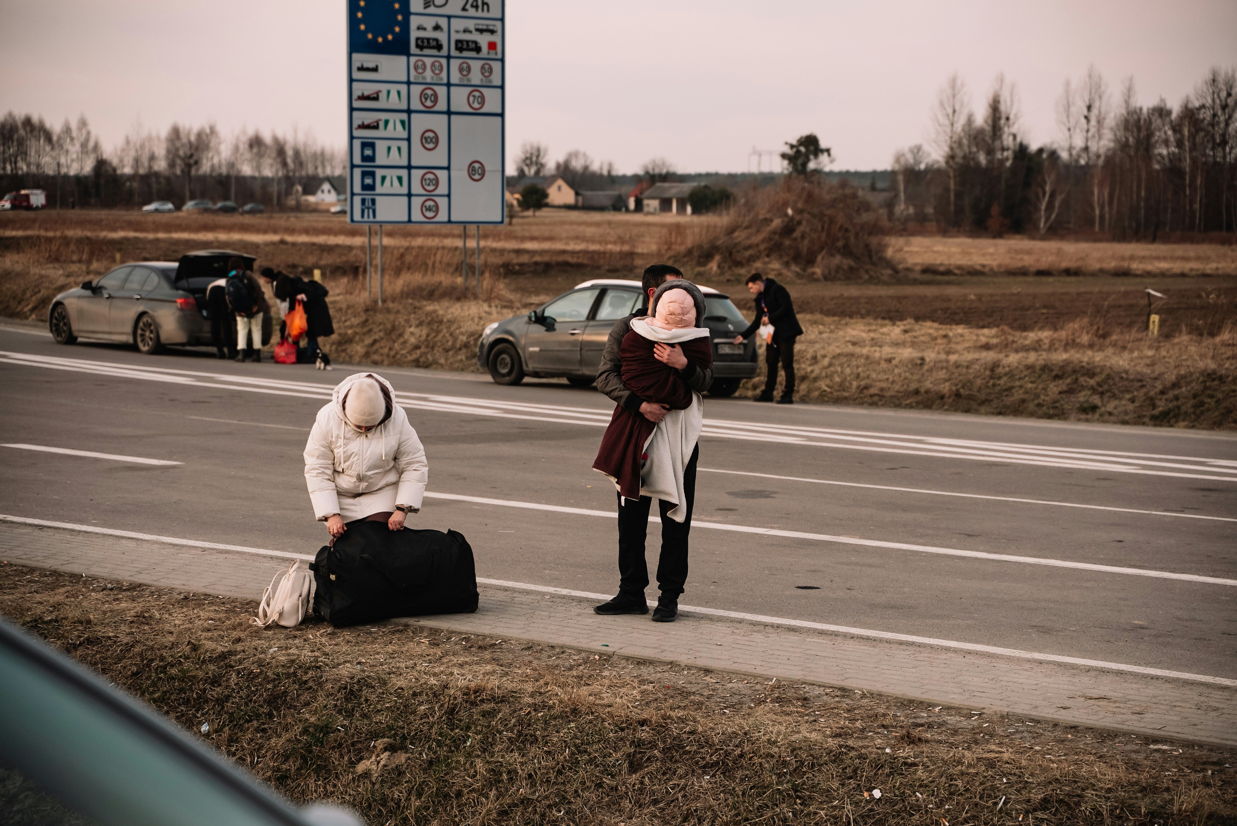 personnes au bord de la route avec leurs affaires 
