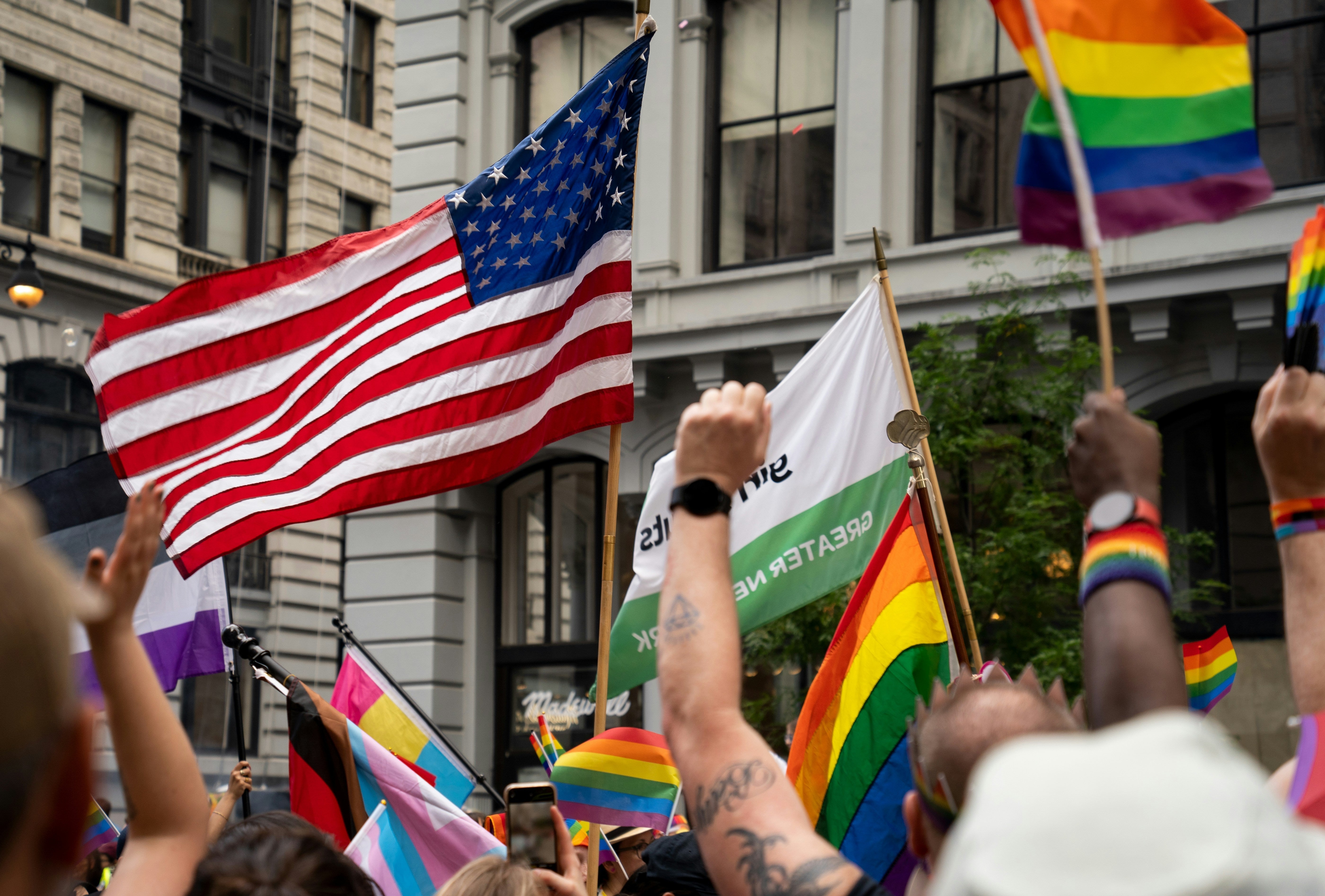 foule lors de la pride avec des drapeaux des USA et de la pride (arc en ciel) au coeur de new york 