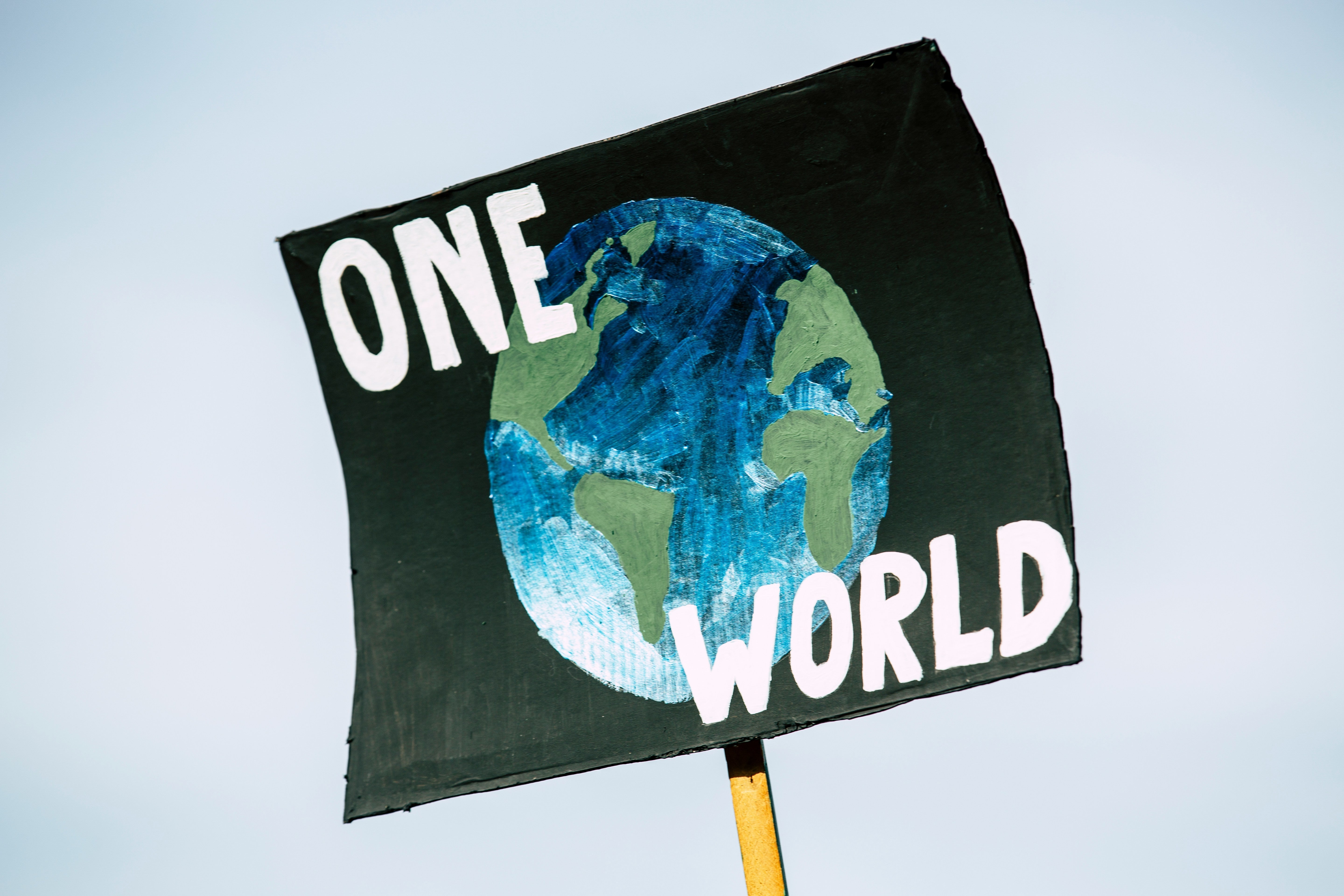 pancarte "one world" avec la Terre