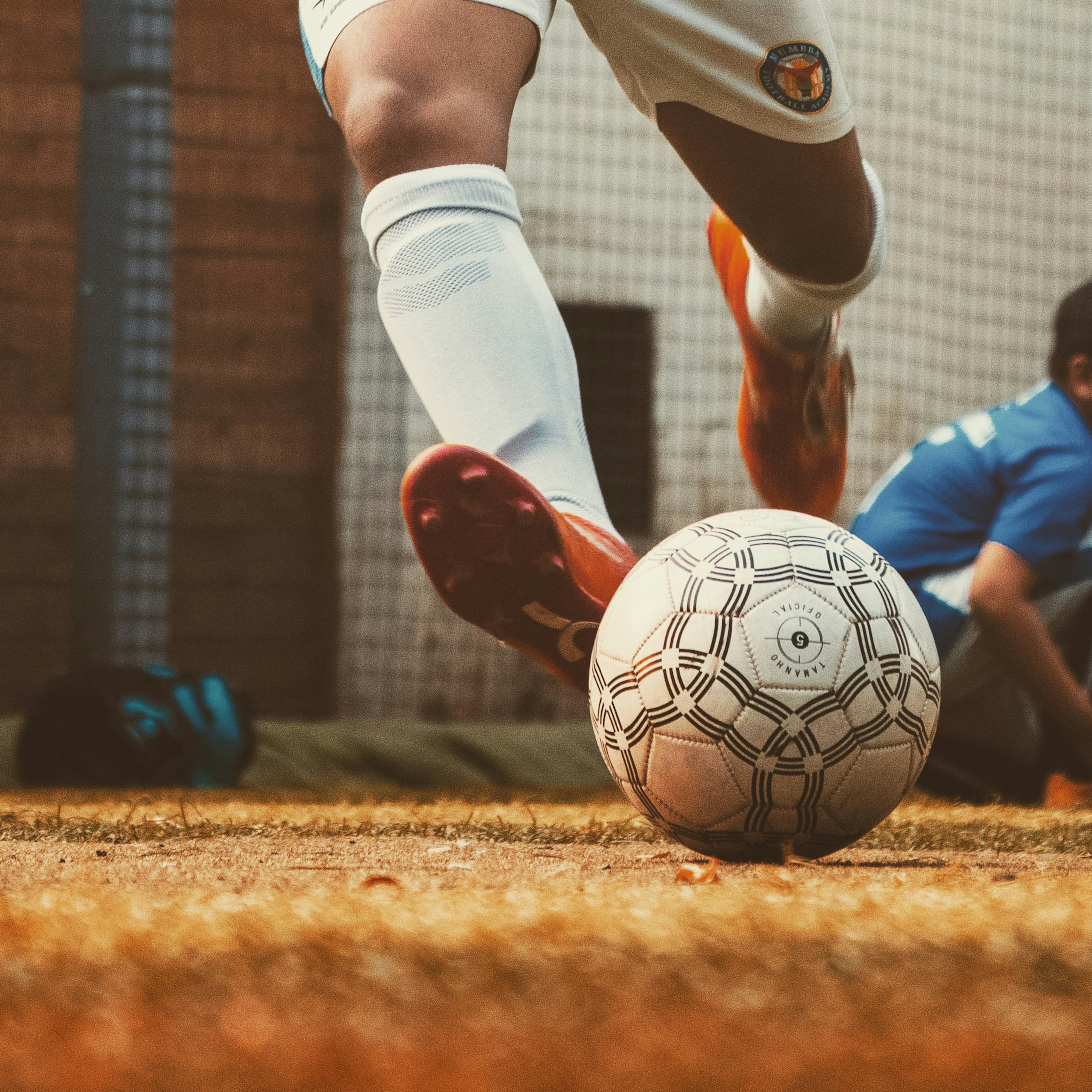 pieds avec des chaussures de crampons, des chaussettes hautes et un ballon de football 