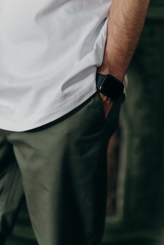 homme avec un pantalon kaki avec t-shirt blanc et montre connectée noire