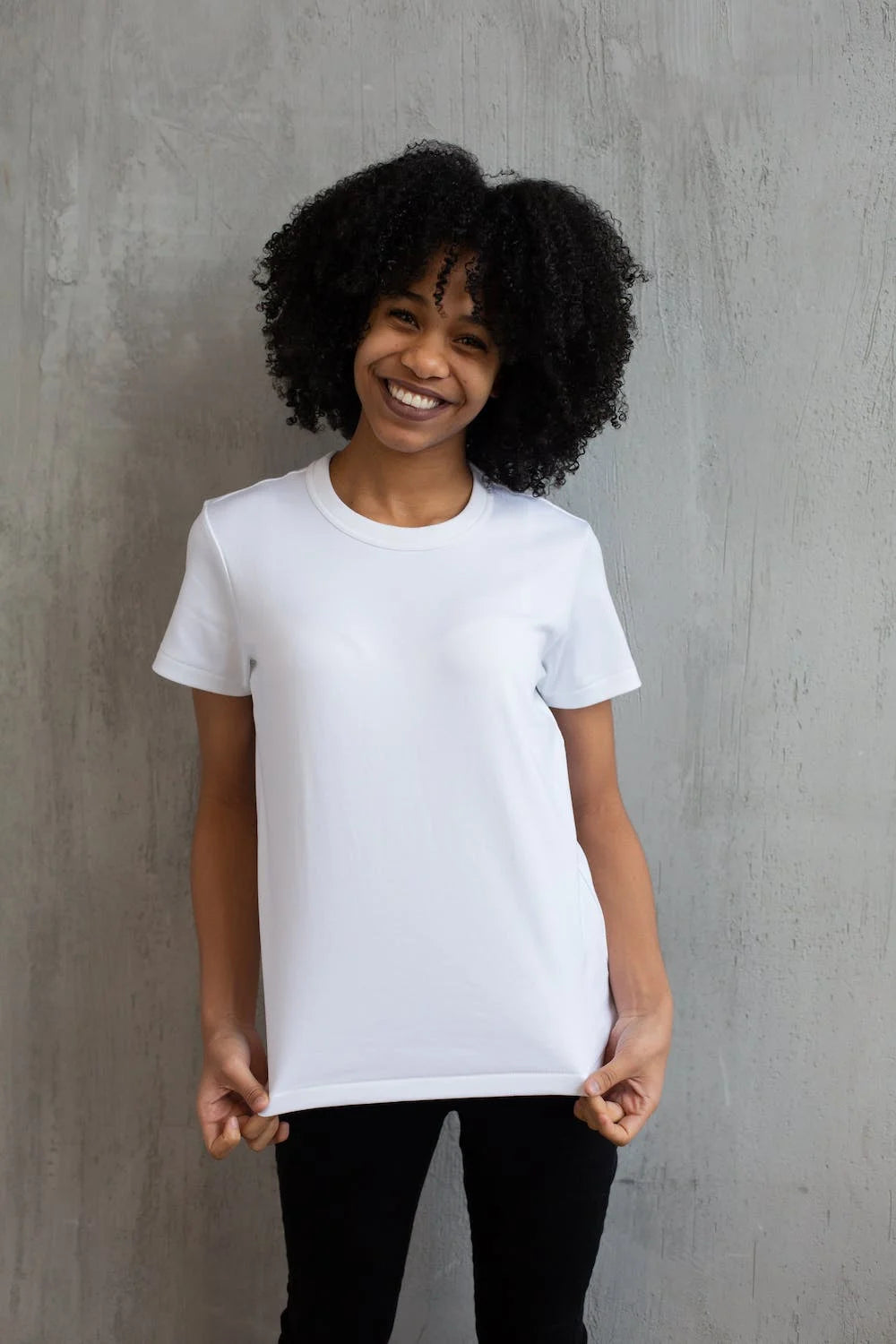 femme souriante portant un t-shirt blanc