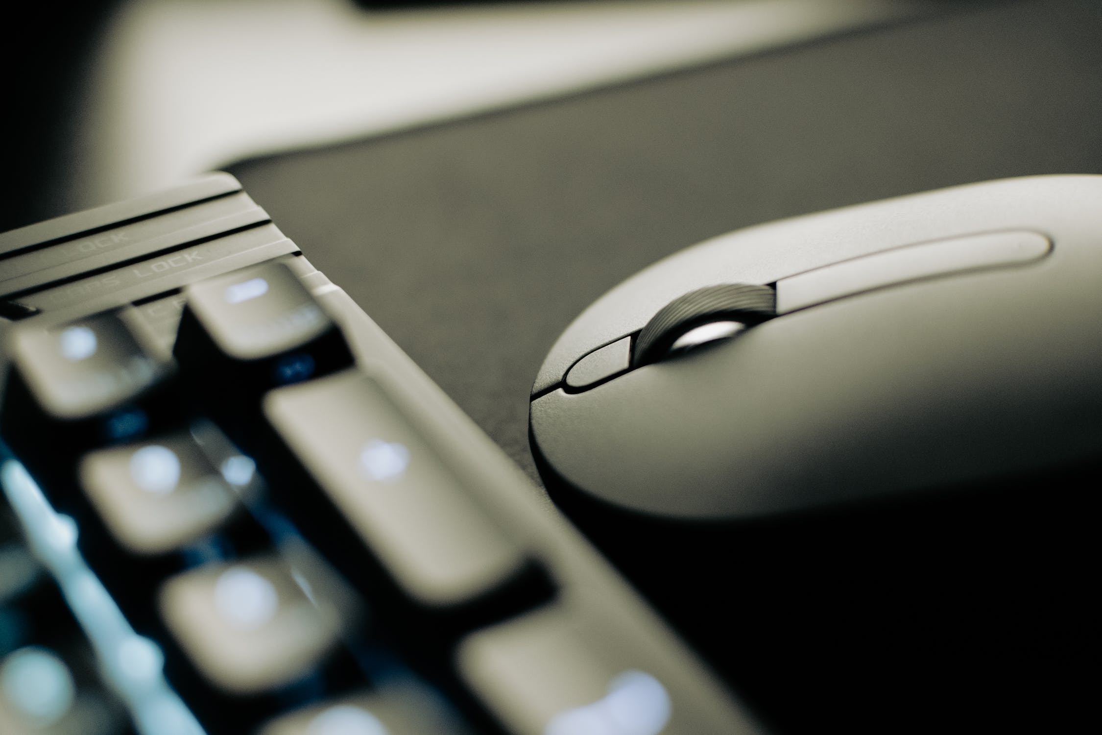 souris-grise-sur-tapis-noir-avec-clavier-a-gauche