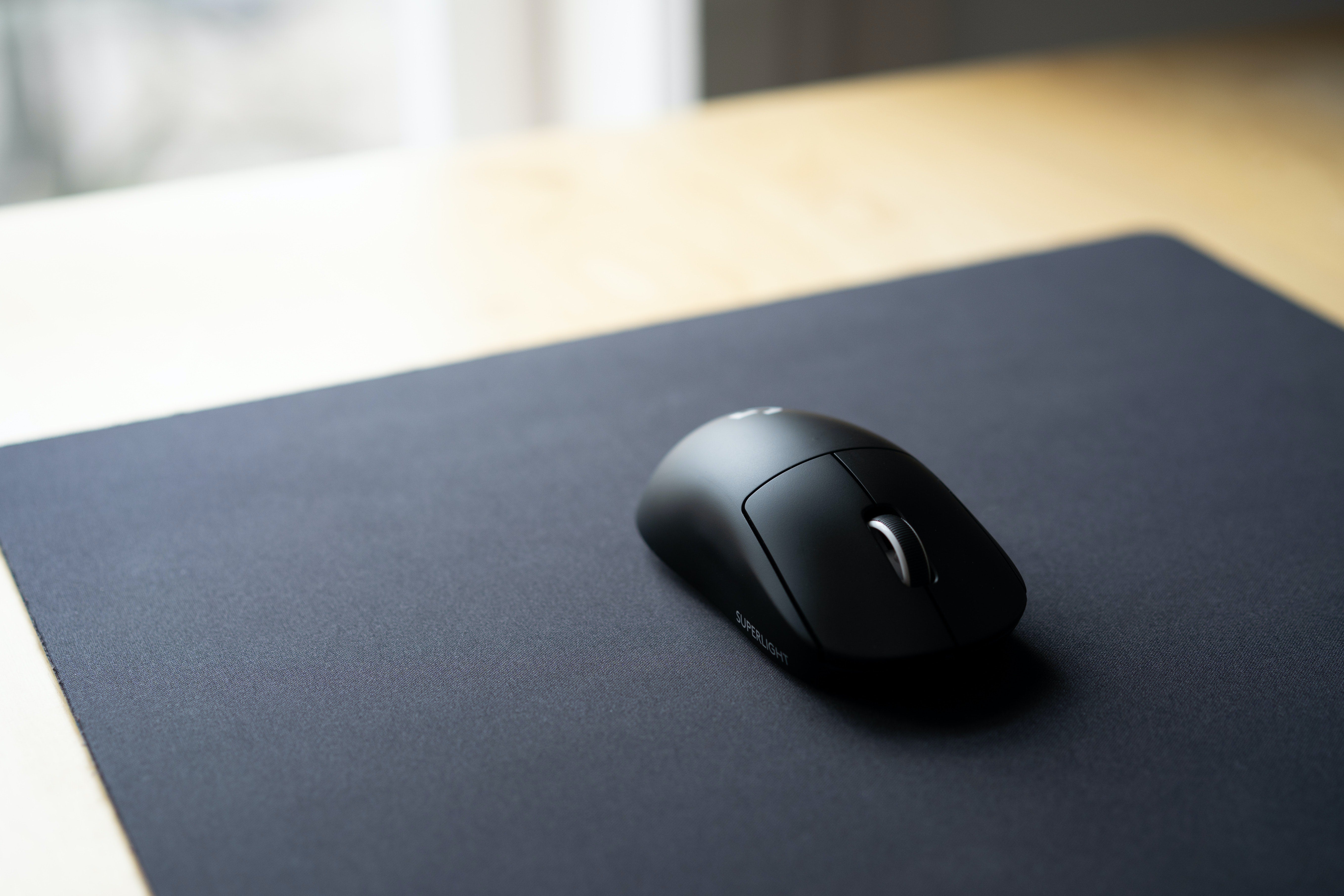 Tapis de souris gris foncé avec une souris noire dessus