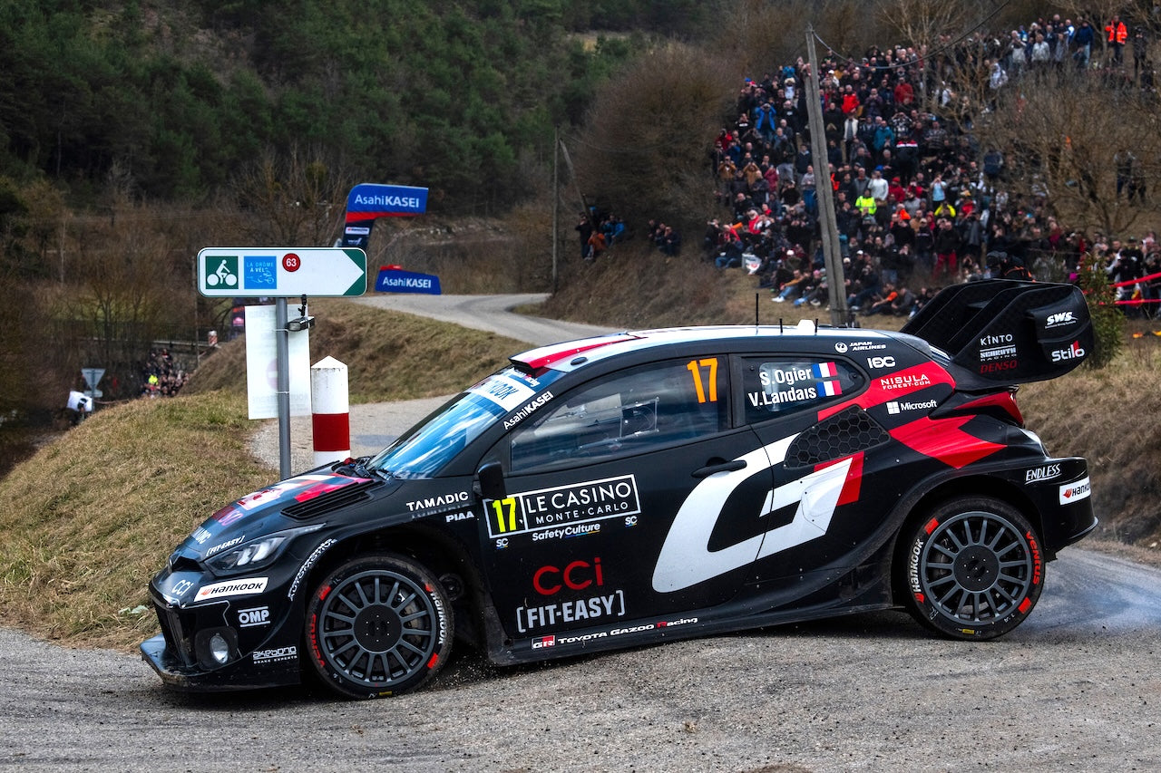 bannière d'une voiture de rallye noir et rouge sur un virage