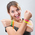 Femme heureuse portant 4 bracelets de couleurs vives en pvc et ajustables