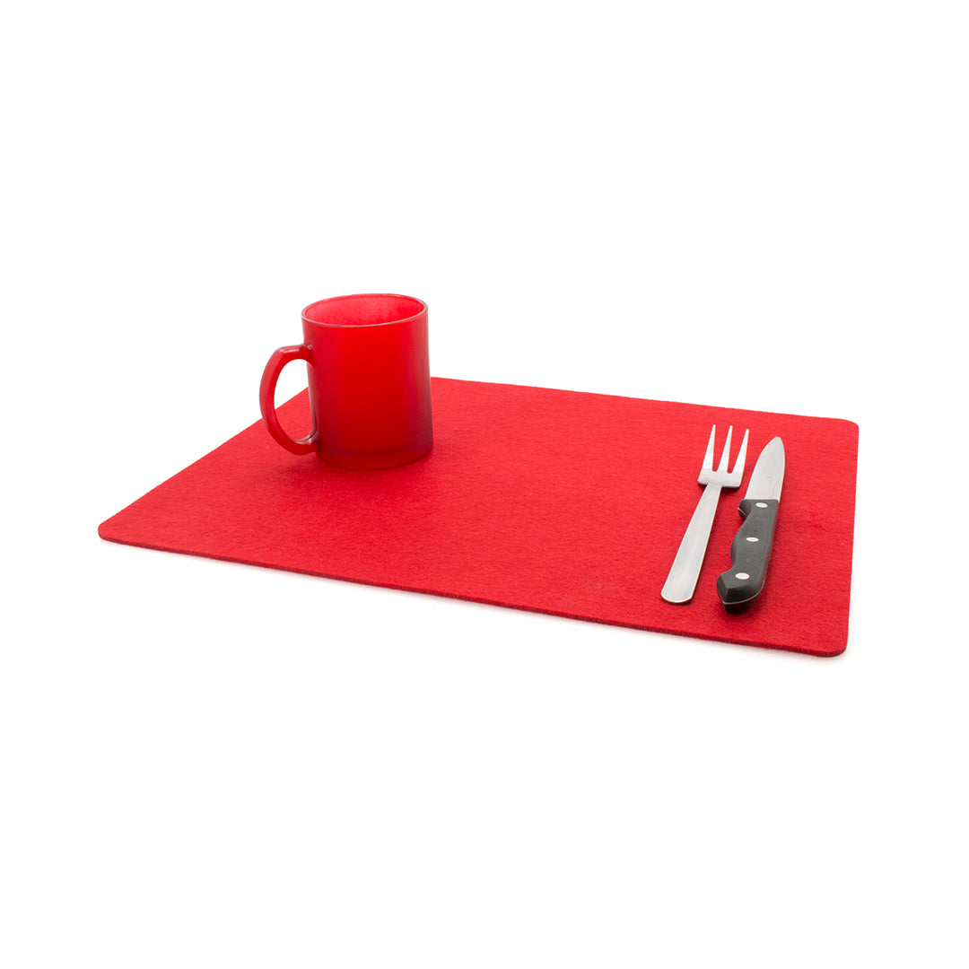 Set de table personnalisable rouge déplié en feutrine. Une tasse rouge, une fourchette à 3 branches et un couteau sont posés sur le set de table rouge en feutrine.