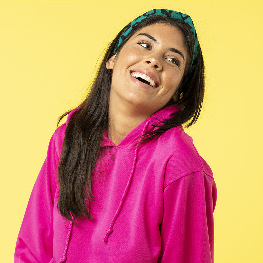 femmes avec un bandana vert et un sweat-shirt rose qui souris