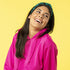femmes avec un bandana vert et un sweat-shirt rose qui souris