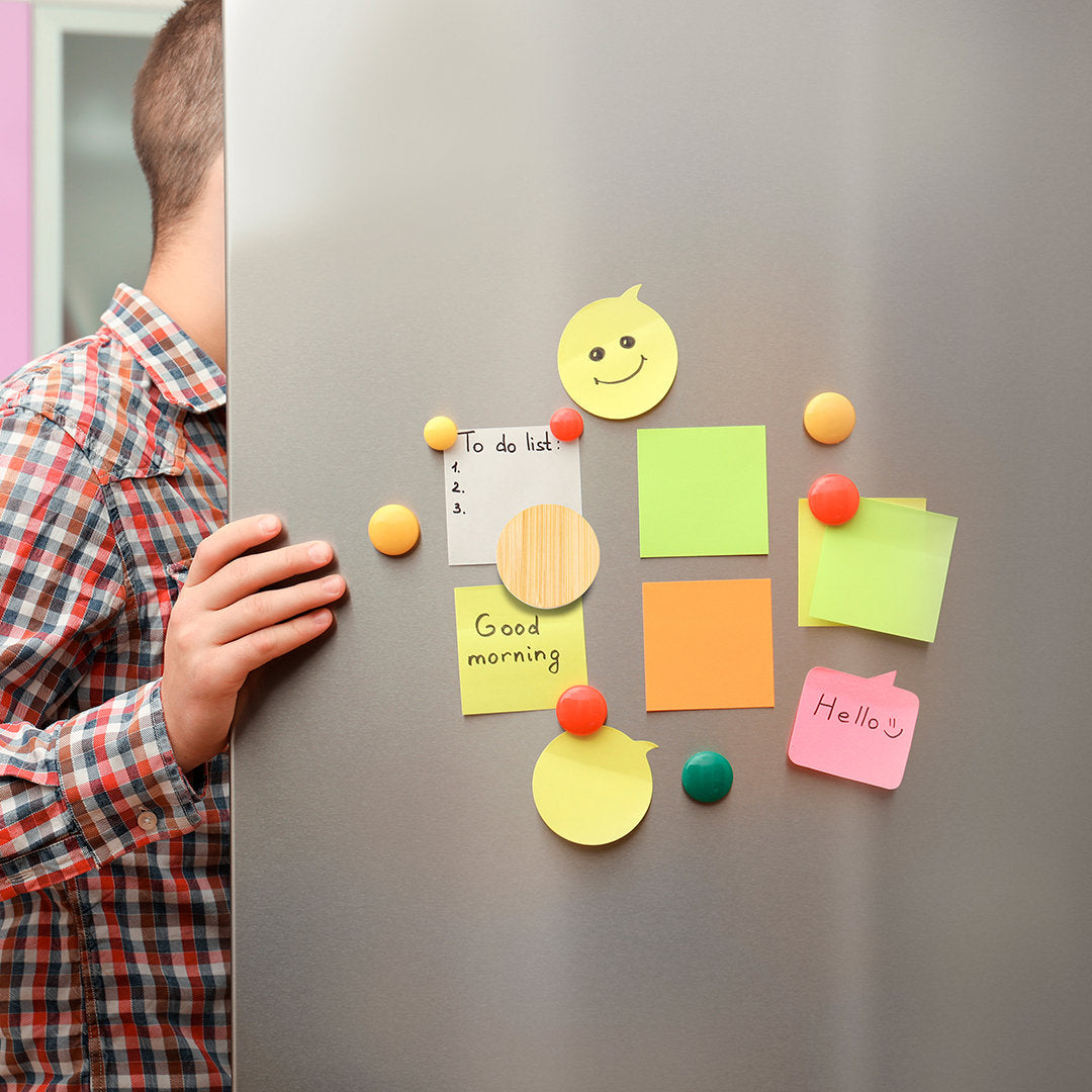 Ouvre bouteille magnétique sur un frigo avec des post it