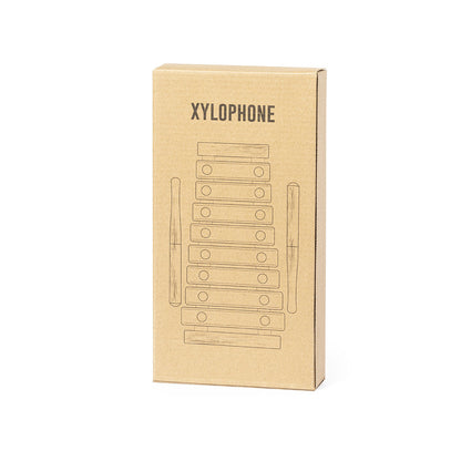 Xylophone en bois naturel et clés métalliques multicolores, présenté dans une boîte individuelle au design élégant en kraft.